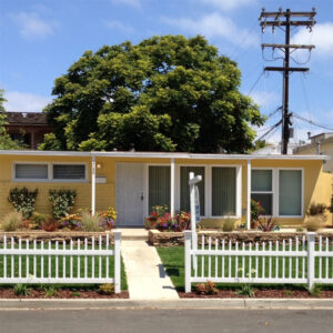 Stanley white vinyl picket fence in front of yellow house