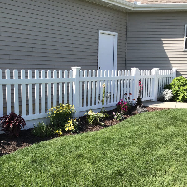 Murton white vinyl picket fence in front of white door